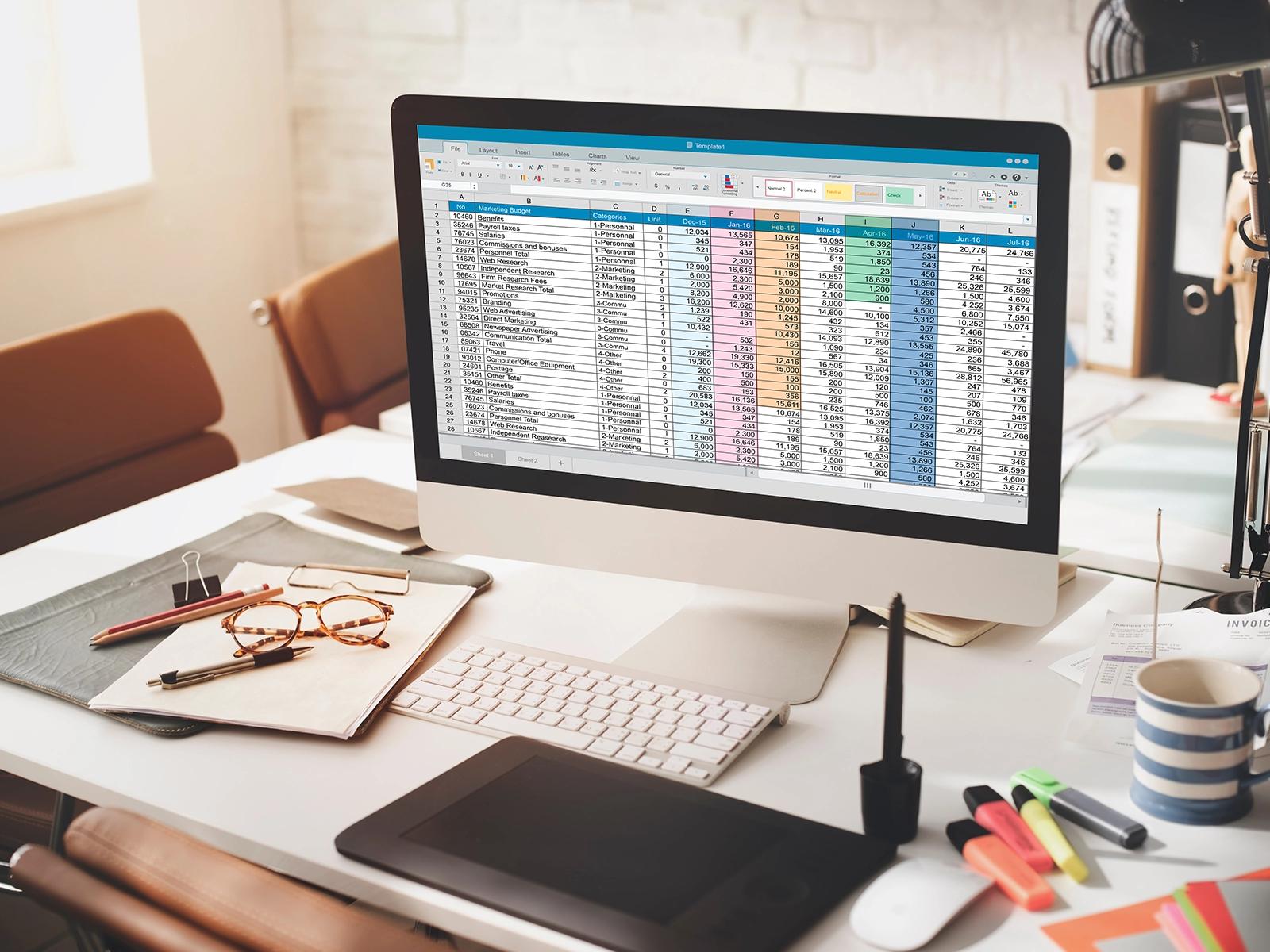An organized desk with a sleek computer displaying colorful spreadsheets